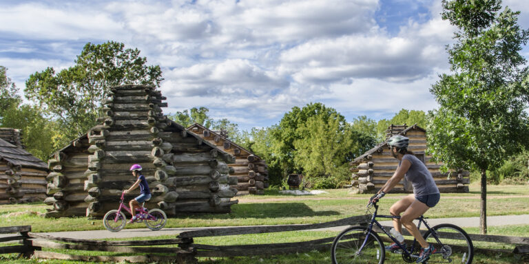 Mother and daughter bike by revolutionary-era forts at Valley Forge.