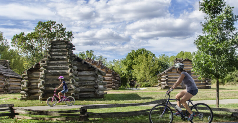 Mother and daughter bike by revolutionary-era forts at Valley Forge.